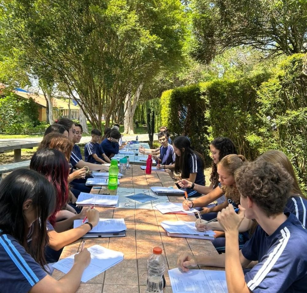Alunos do Ensino Médio estudando em mesa ao ar livre