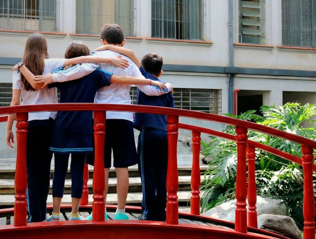 Alunos abraçados na ponte vermelha do Colégio Sion